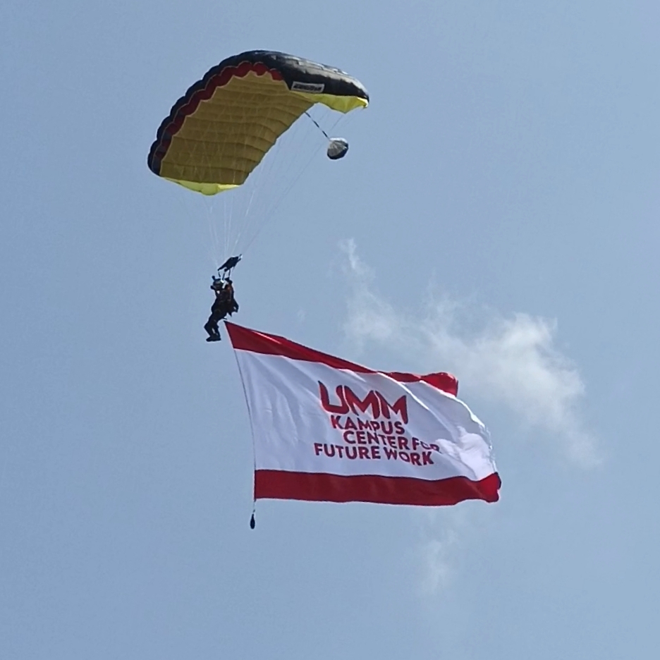 Aksi penerjun payung membawa bendera UMM. (Foto: Agus N/reportasemalang)